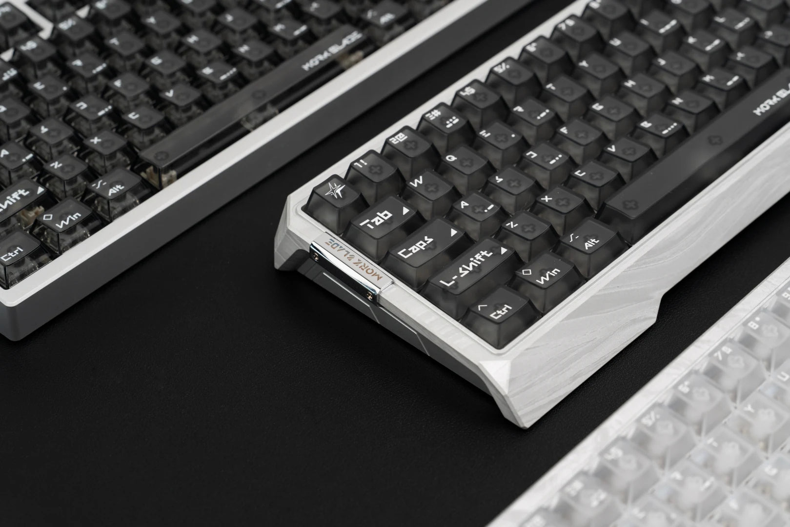 An angled view of the new Morkblade GH60 case with black keycaps, showing its silver side profile and corner detail.